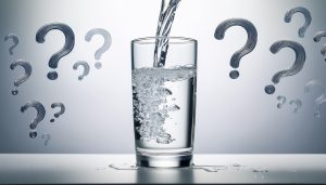 water glass with question marks. concept of questioning what's in drinking water.